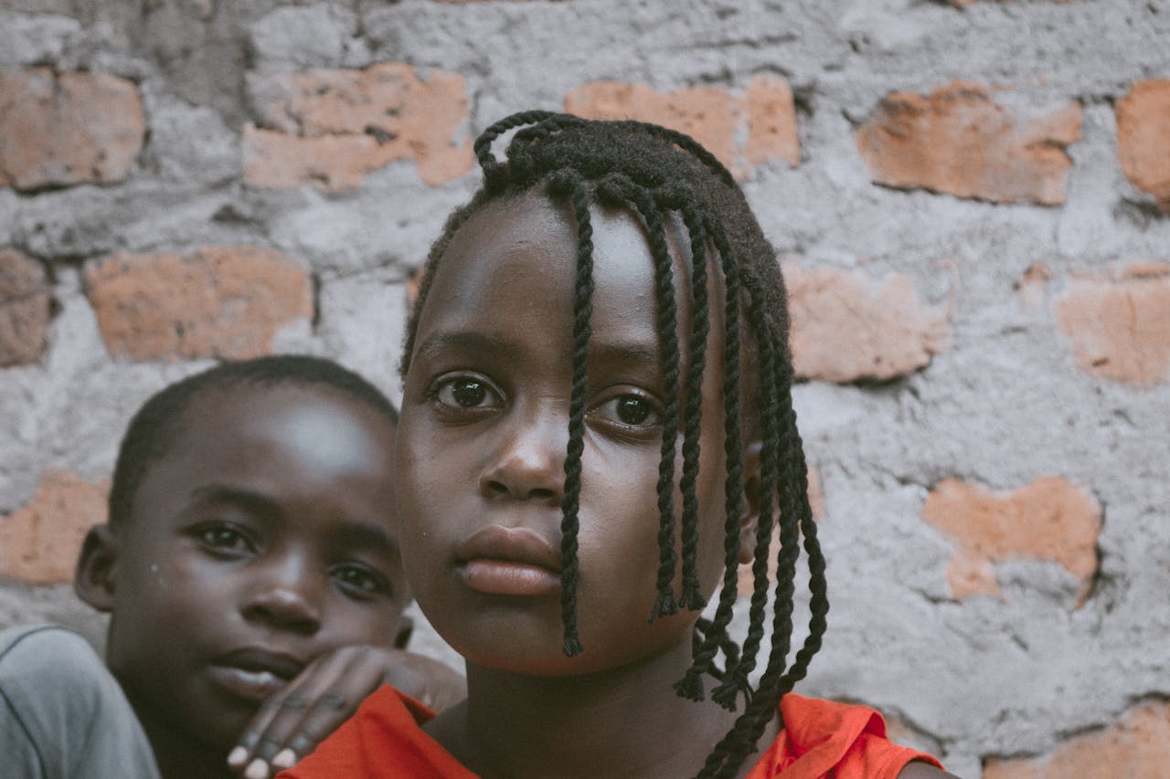 Portrait of children with braided hair, captured outdoors in Mbale, Uganda.